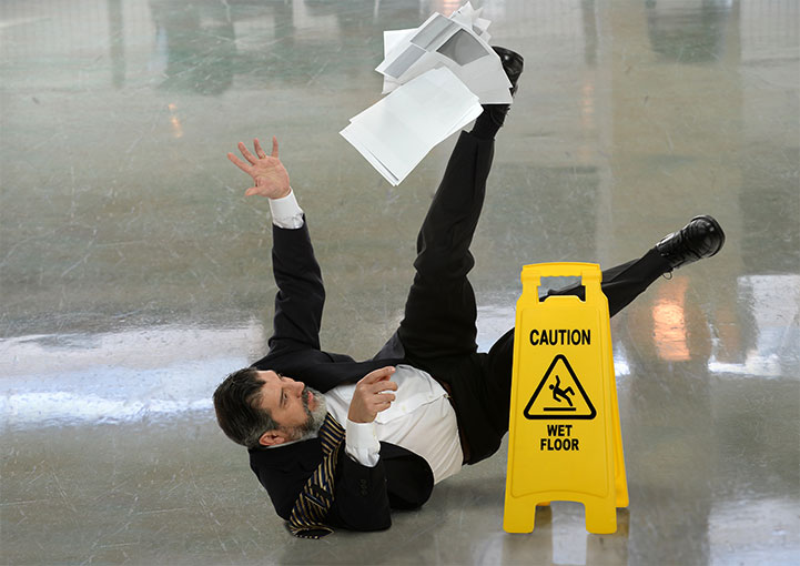 Man falling in a caution wet floor area